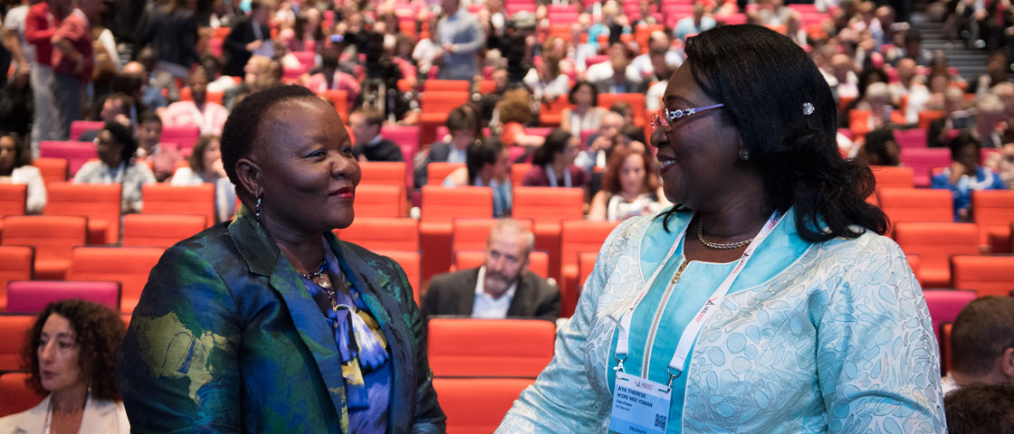 Two people face one another in front of a crowded auditorium